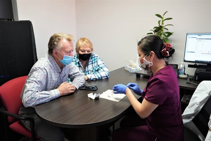 audiologist showing patient hearing aids